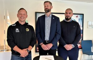 Tre män står bredvid varandra. Foto.