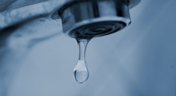 Vattendroppe kommer ut ur en dricksvattenkran. Foto.