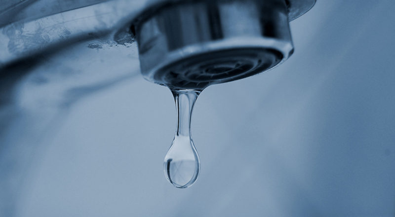 Vattendroppe kommer ut ur en dricksvattenkran. Foto.